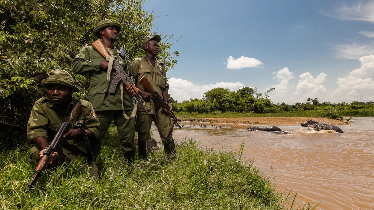 Bienvenue Tsongo, Jean Paul Bisika and Sebastien Kaposo, part of Virunga’s 700-strong ranger force, guard the Lulimbi River and its resident hippos on the park’s eastern border. © Adam Kiefer