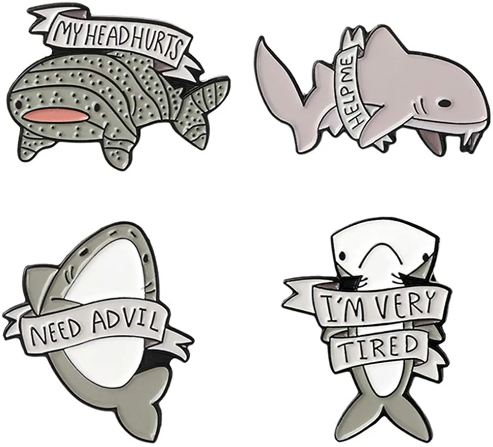 Four cute shark enamel pins in different positions with little messages such as 'my head hurts'