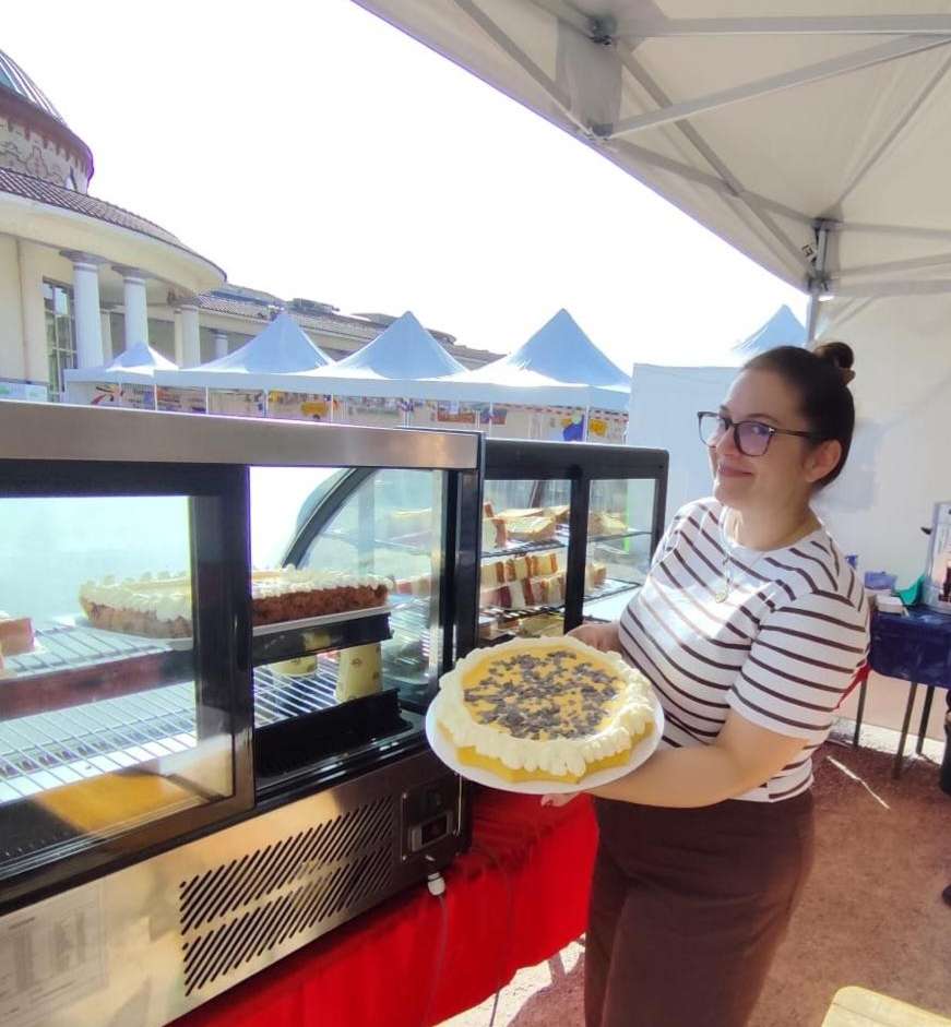 Bäckerin mit Tortenangebot beim Stadtfest in Contrexéville