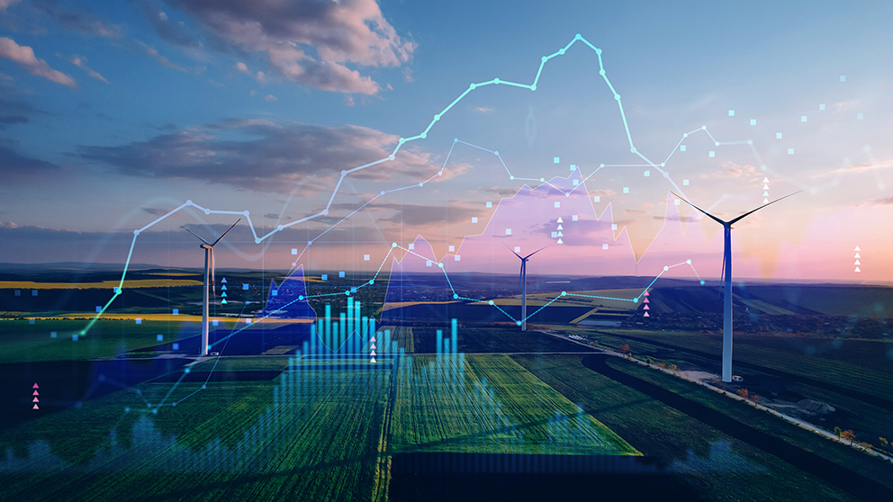 Getty Images/Galeanu Mihai Über einem Landschaftsbild mit Windrädern leuchten Datenpunkte und Diagramme, als Symbolbild für den Industriestrompreis