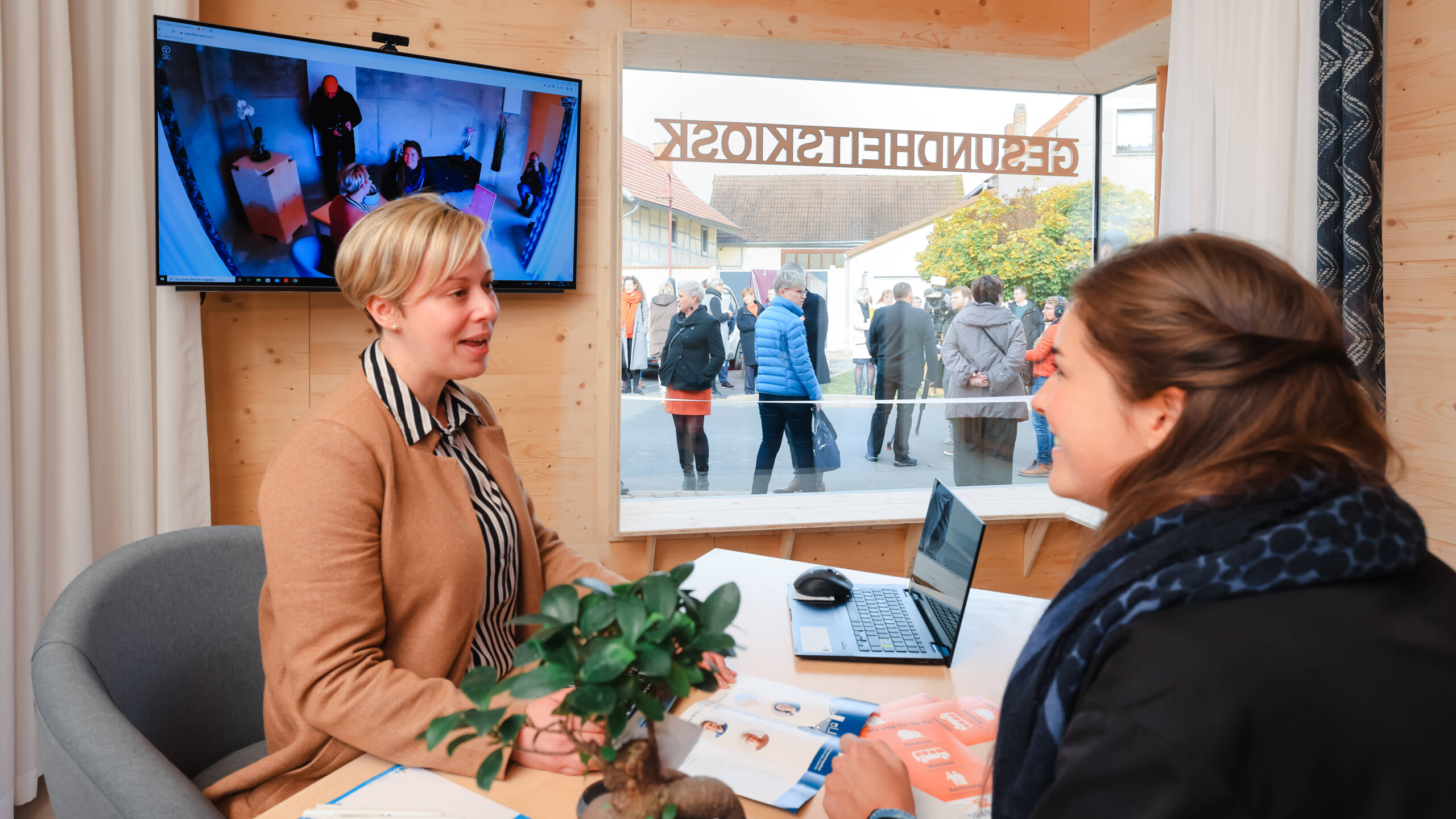 Carolin Anders, Agathe-Beraterin, spricht vor der Eröffnung des ersten Thüringer Gesundheitskiosks mit einer Interessentin. (Foto: IMAGO / ari)