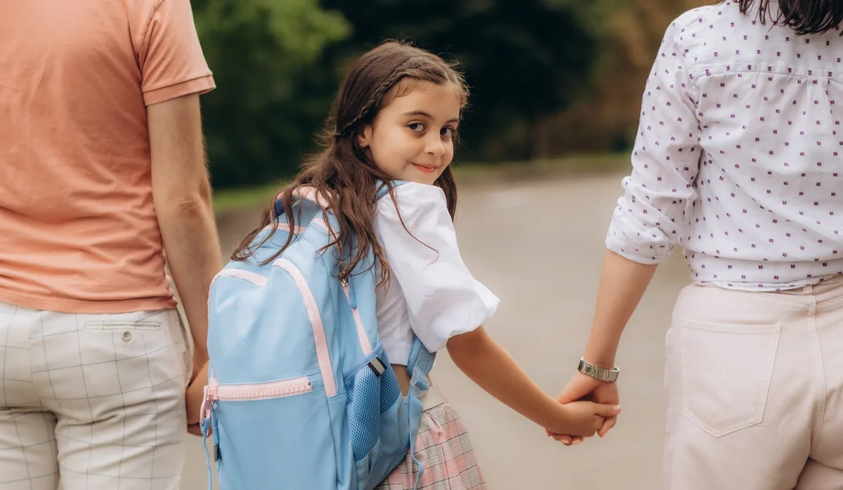 Cute little girl going to school with her parents Kritik an der Privatschule