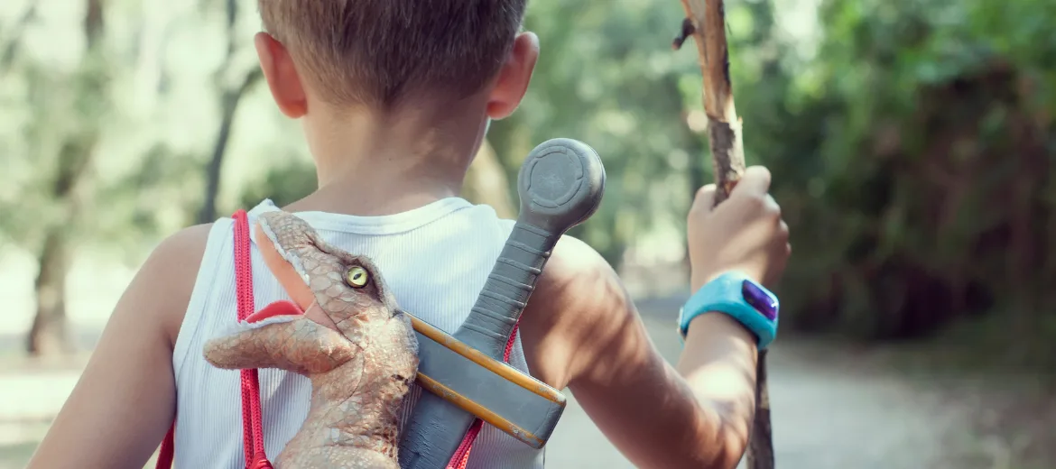 24-11-école-tracking-magazine-suisse-parents-hg École, tracking : Garçon avec sac à dos, dinosaure de jeu et smartwatch dans la forêt