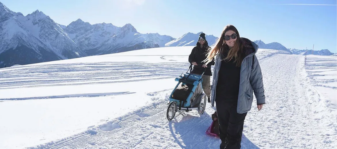 24-12-un-week-end-à-scuol-magazine-des-parents-suisses-hg Un week-end à Scuol : Famille se promenant en traîneau