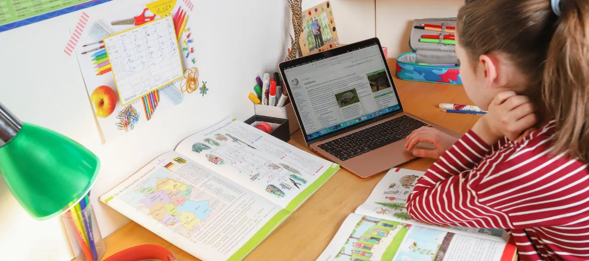 24-12-apprentissage-école-mercator-suisse-magazine-parents-suisses-fritz-et-fraenzi-hg Une jeune fille en train d'étudier à son bureau