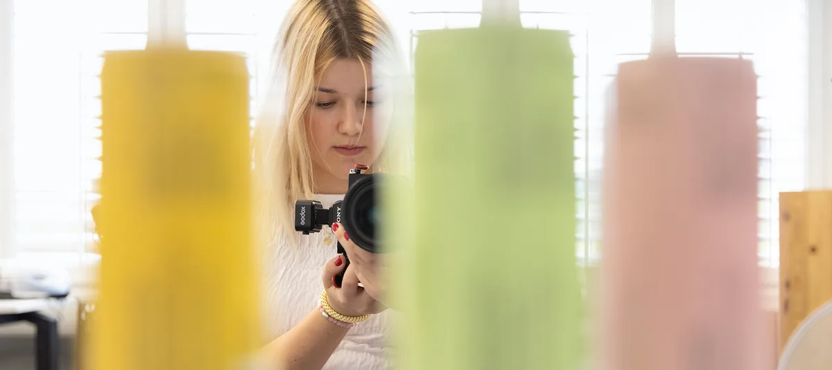 Interactive Media Designerin; Nena Schenk; koller.team gmbh; Appenzell In der Schnupperlehre Berufe kennenlernen. Auf dem Bild ist ein Mädchen im 4. Lehrjahr als Interactive Media Designerin EFZ mit einer Kamera in der Hand.