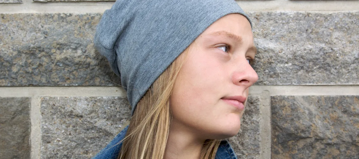25-04-schulabsentismus-kosmos-kind-schweizer-elternmagazin-hg Schulabsentismus: Teenagermädchen lehnt sich an eine Wand und blickt in die Ferne