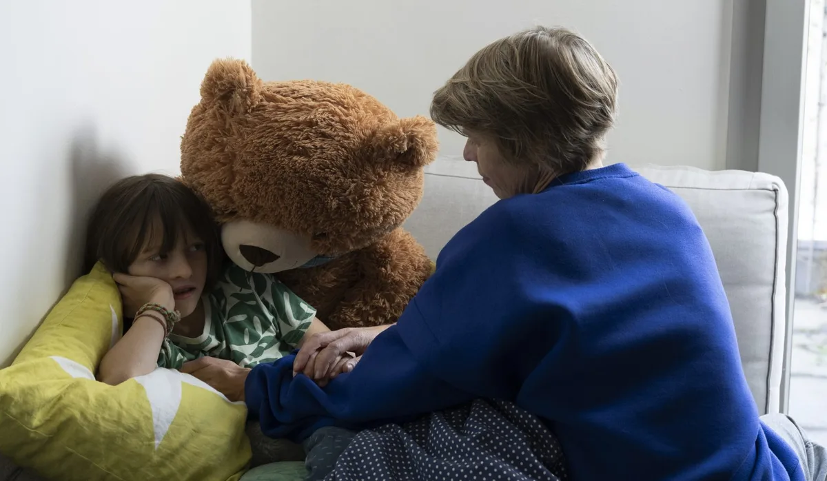 Töchter Co-Regulieren: Mutter sitzt am Bettrand und beruhigt ihre Tochter