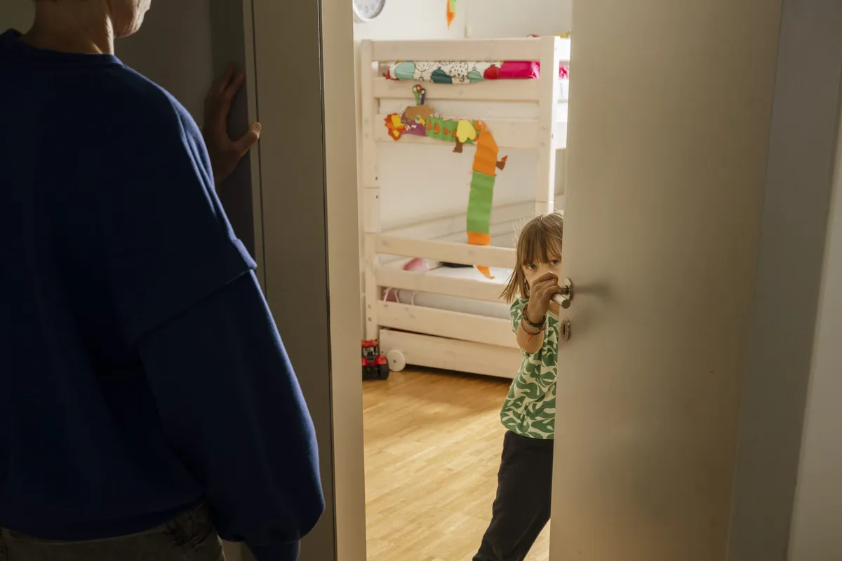 25-12-vaeter-wut-dossier-zweitstoff-schweizer-elternmagazin-hg Les pères et la gestion de la colère chez les enfants : un père se tient devant la chambre de ses enfants ; une petite fille ouvre la porte
