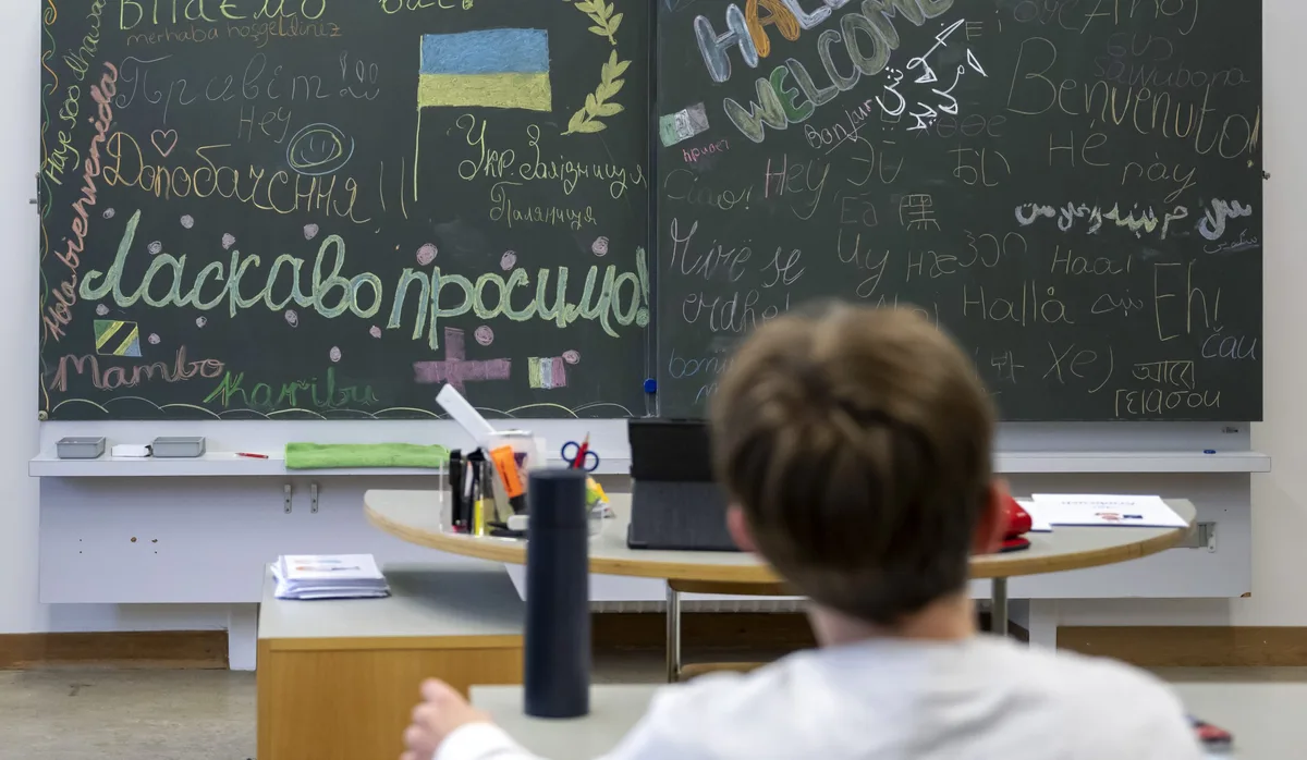 DEUTSCHKURS, SPRACHKURS, DEUTSCH FUER AUSLAENDER, UKRAINE RUSSLAND KRIEG, Krieg: Bub sitzt in einem Klassenzimmer und schaut auf die Wandtafel