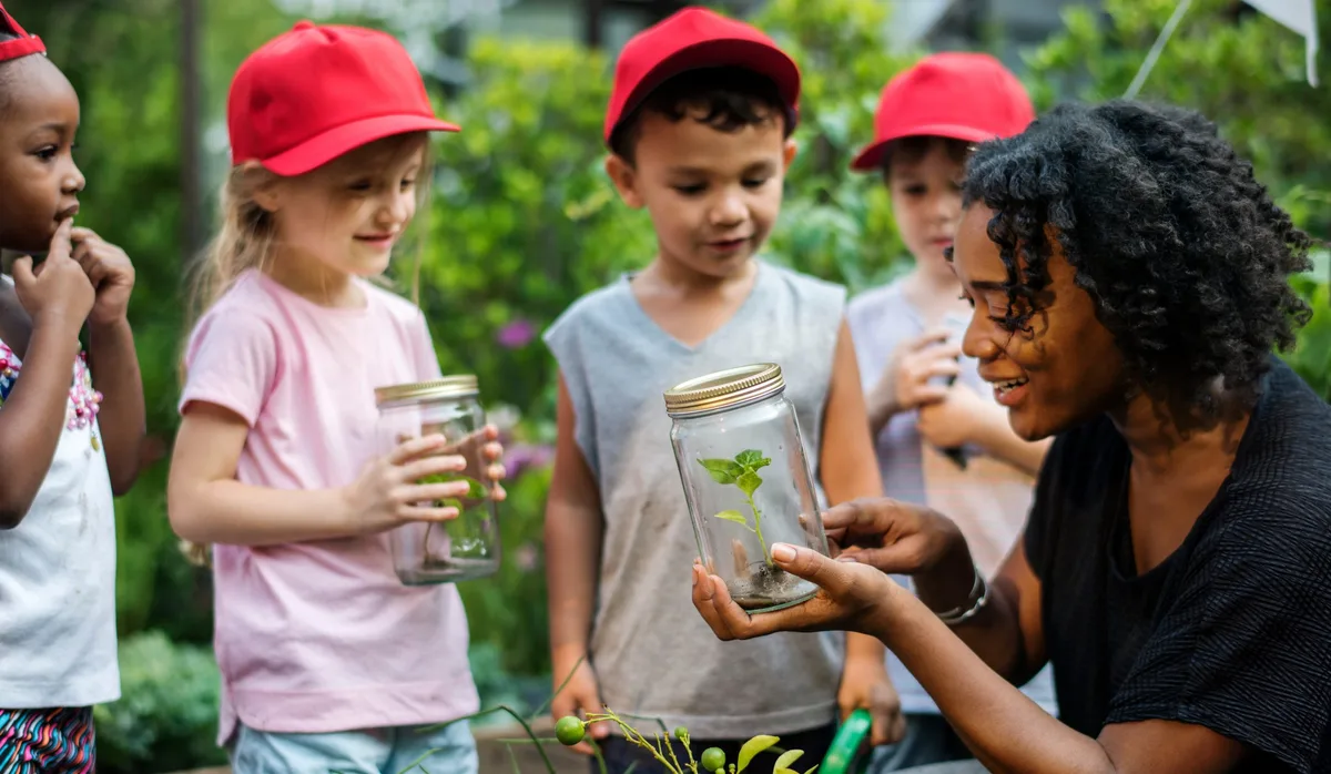 Lehrperson mit Kinder im Schulgarten