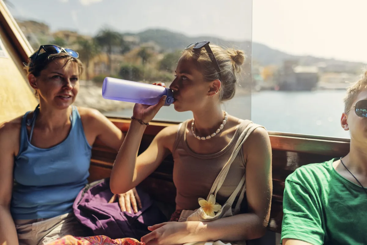 Mother and teenage kids waiting for the ferry boat to depart. Frau und Stiefkinder auf einem Schiff