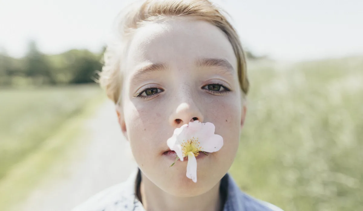 Bub mit Blume im Mund