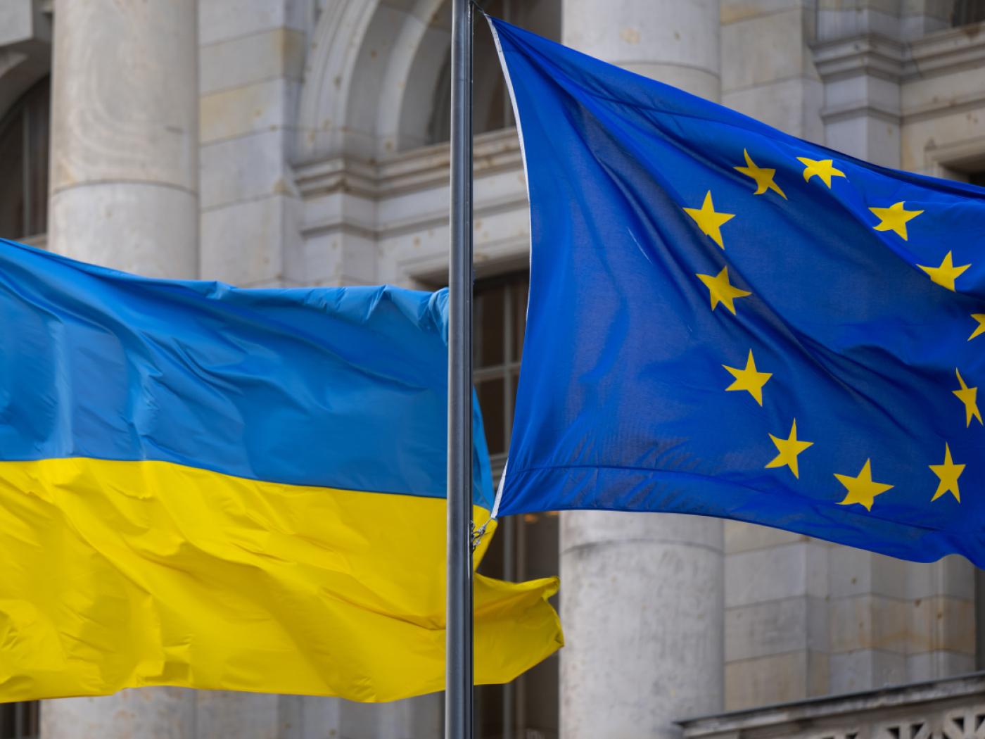 ARCHIV - Die Nationalflagge der Ukraine und die Flagge der EU wehen im Wind. Foto: Monika Skolimowska/dpa