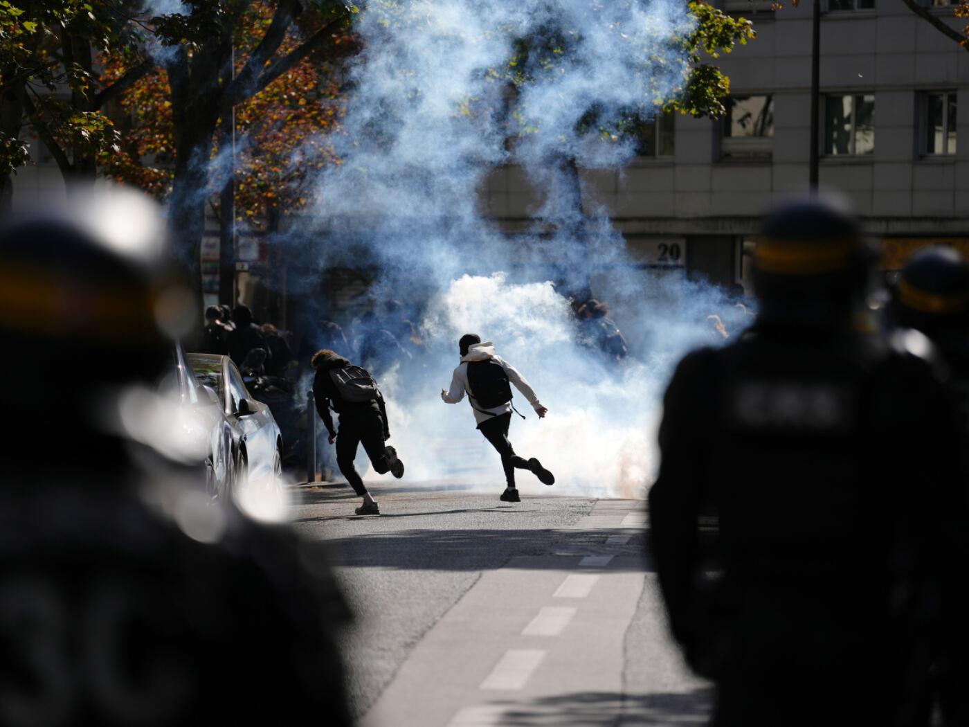 Schüler rennen durch Tränengas, während sie bei einer Demonstration gegen unterfinanzierte Schulen mit Polizisten zusammenstoßen. Seit Tagen protestieren Schülerinnen und Schüler an den Oberschulen. Foto: Aurelien Morissard/AP/dpa