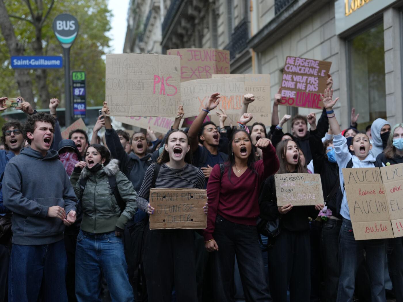 Schüler skandieren vor einem blockierten Gymnasium Parolen, um gegen die mangelnde Ausstattung der Schulen zu protestieren. Foto: Thibault Camus/AP/dpa