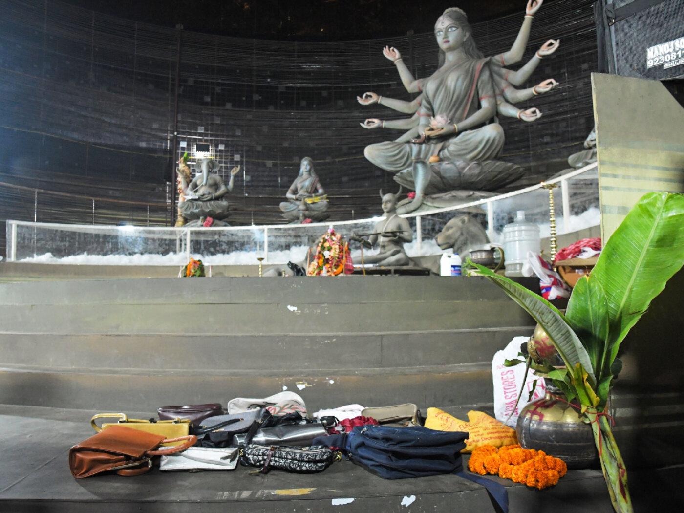 Gegenstände, die von Gläubigen zurückgelassen wurden, liegen nach einer Massenpanik in Kolkata, Indien, auf dem Boden einer Kultstätte für das hinduistische Durga-Puja-Fest. Foto: STR/AP/dpa