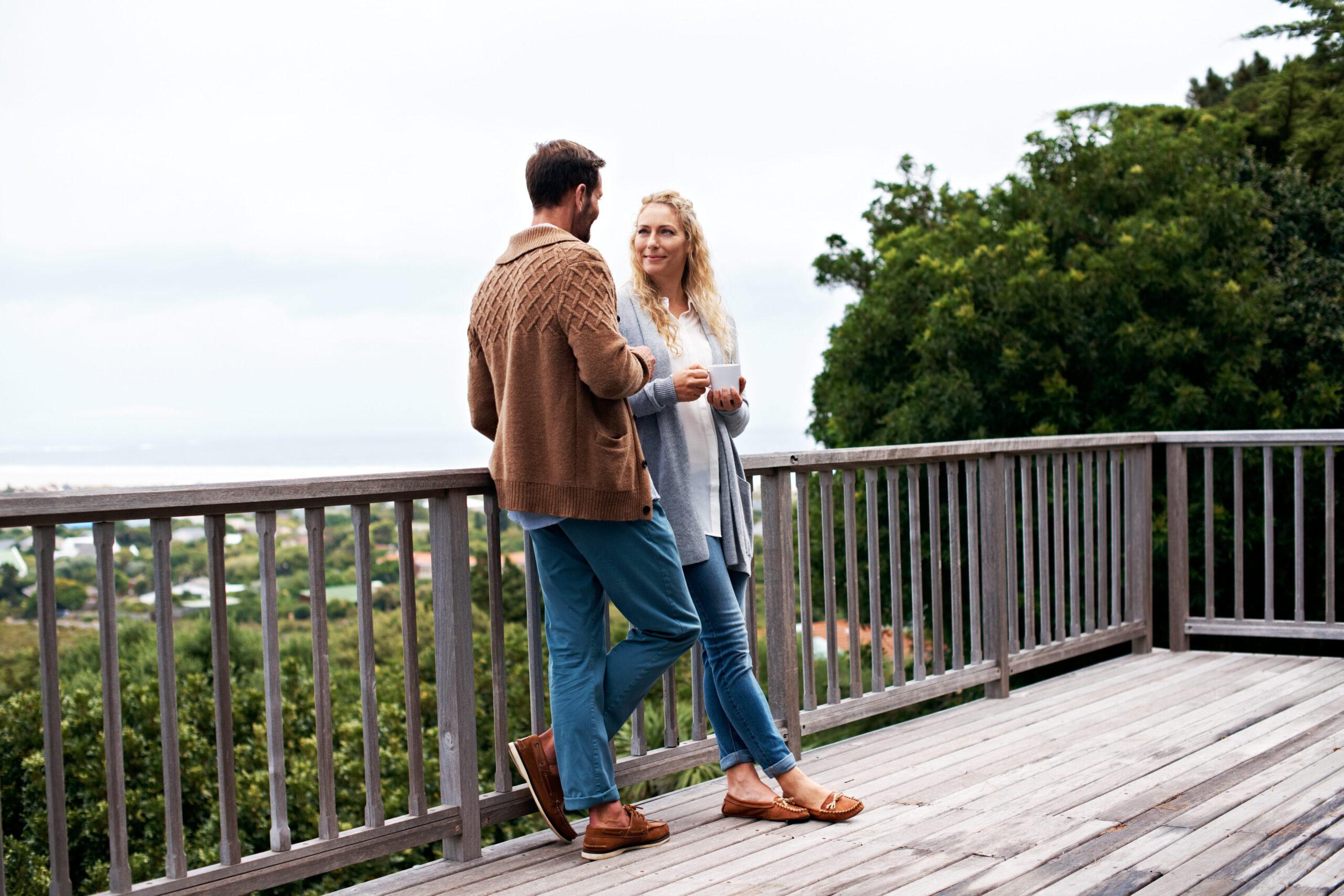 Morning, conversation and couple with coffee on balcony for bonding on vacation, break and relax outdoor. Marriage, happy mature people and drink for connection, relationship or talk at holiday house.