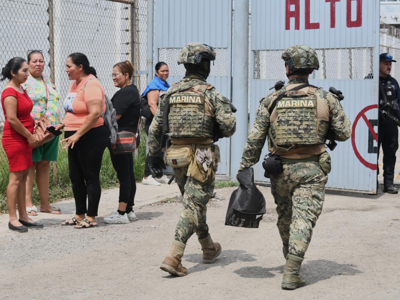 Angehörige von Häftlingen stehen während Auseinandersetzungen im El-Castillo-Gefängnis neben Offizieren der mexikanischen Marine. Foto: Fausto Camacho/AP/dpa