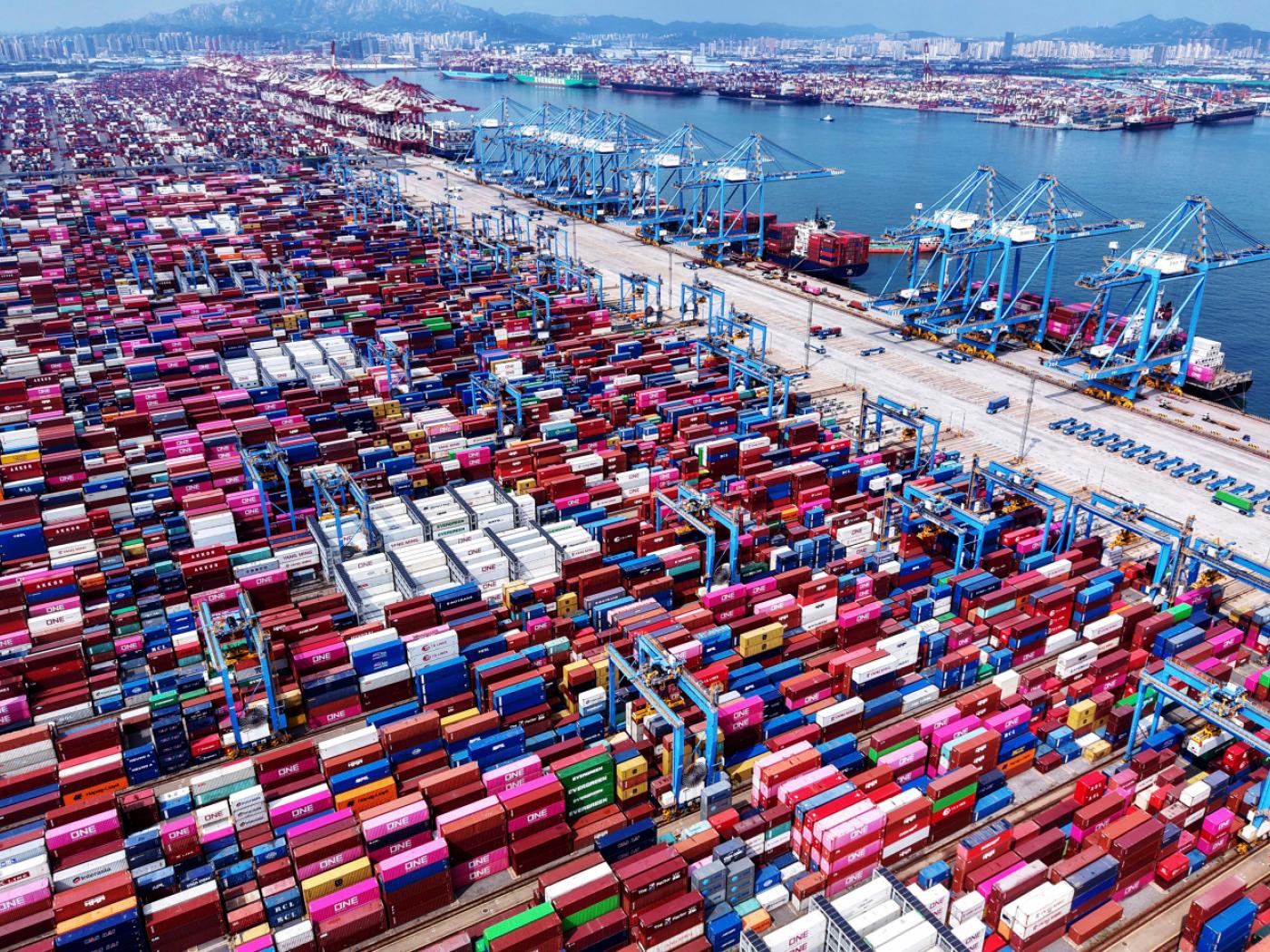 ARCHIV - Kräne entladen Container von Schiffen an einem Containerterminal in der ostchinesischen Provinz Shandong. Foto: Uncredited/CHINATOPIX via AP/dpa