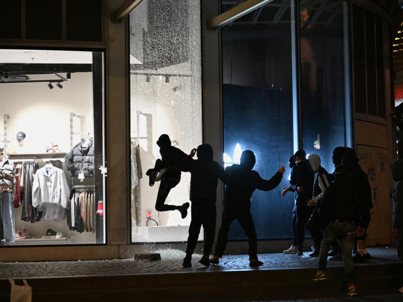 dpatopbilder - Jugendliche zerschlagen bei Zusammenstößen zwischen Demonstranten und der Polizei in Paris eine Schaufensterscheibe. Foto: Emma Da Silva/AP/dpa
