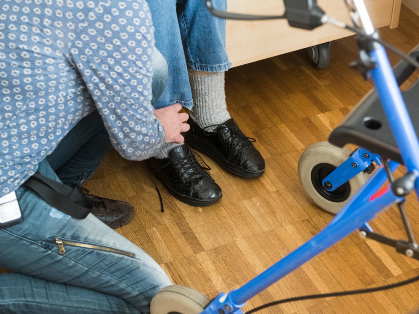 Eine Pflegefachfrau hilft einer demenzkranken Bewohnerin in ihrem Zimmer beim Schuhe anziehen, fotografiert am 1. November 2021 in der Hausgemeinschaft fuer Demezkranke «Niklausen» des Kompetenzzentrums fuer Lebensqualitaet «Schoenbuehl» in Schaffhausen. (KEYSTONE/Goran Basic)