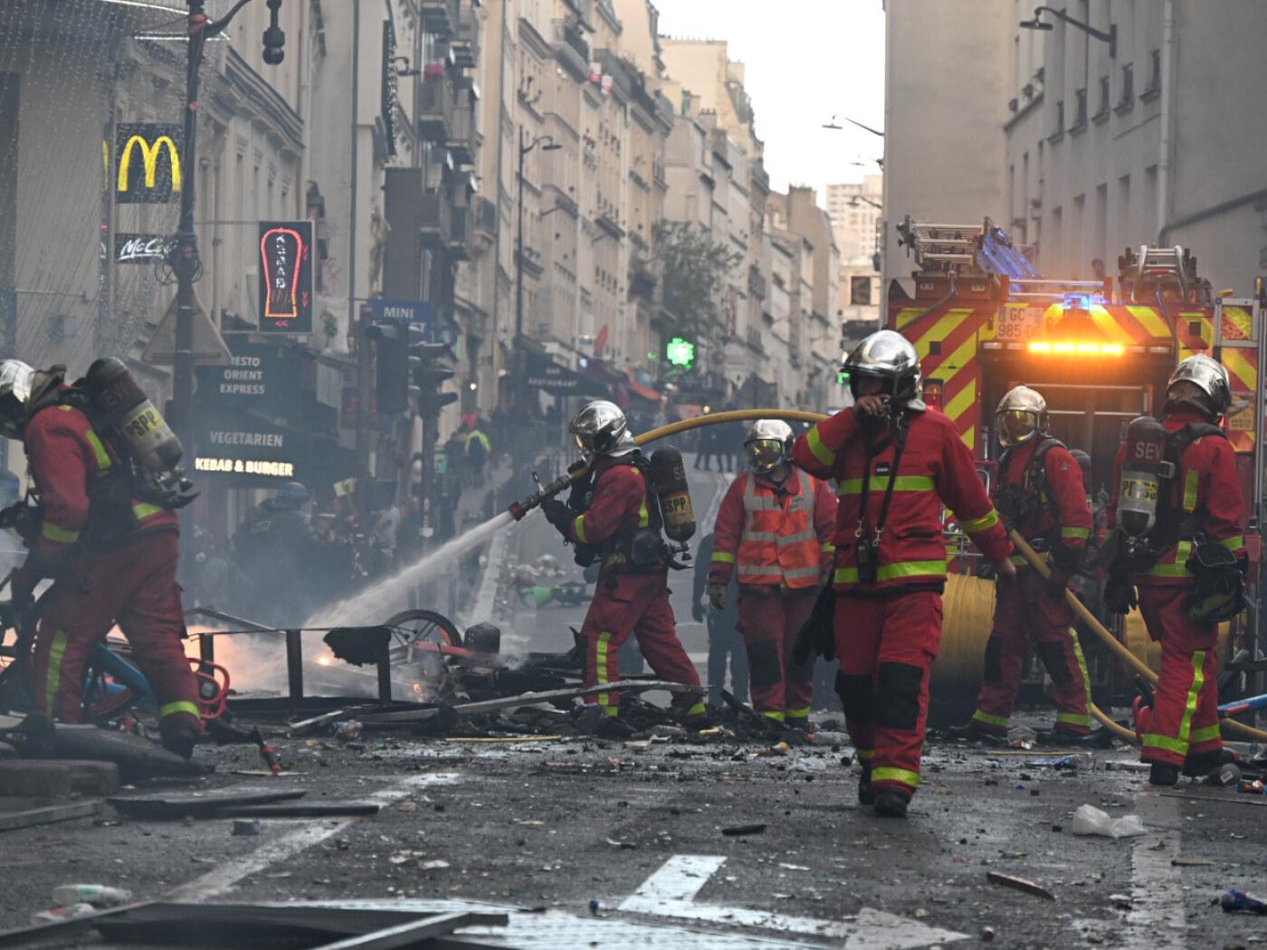 dpatopbilder - Feuerwehrleute löschen einen Brand während einer Demonstration gegen steigende Lebenshaltungskosten, bei der sich die Teilnehmer den Forderungen der Studenten anschlossen haben. Foto: Emma Da Silva/AP/dpa