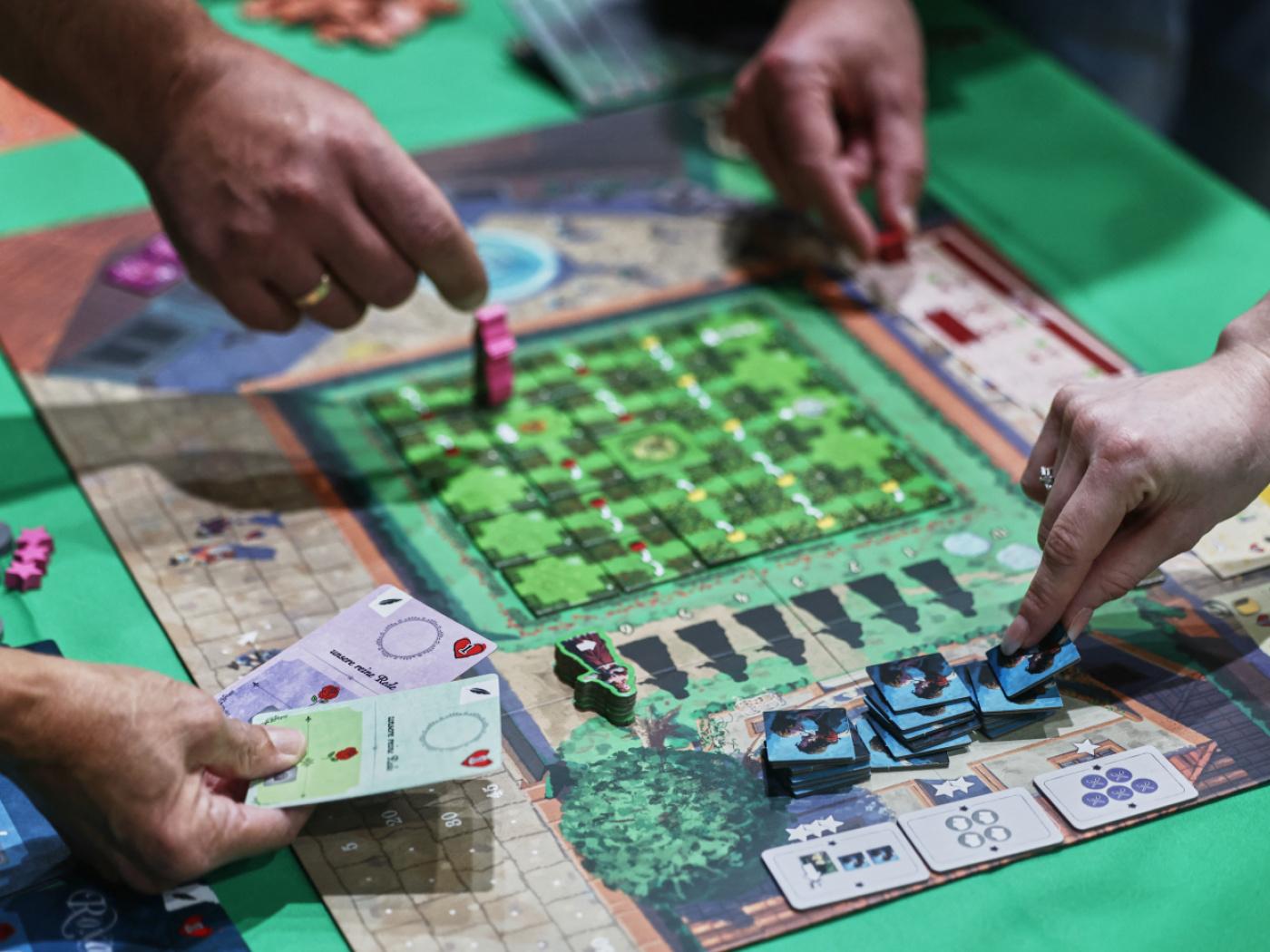 Menschen spielen auf der Publikumsmesse «Spiel Essen» das Brettspiel «Roxane». Foto: Oliver Berg/dpa