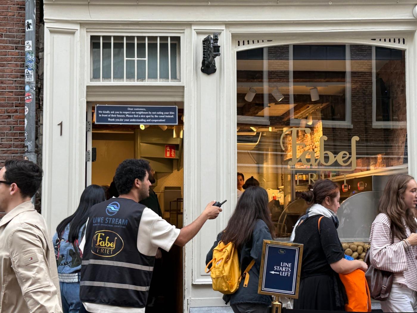 PRODUKTION - Menschen stehen vor einer Snackbar. Fabel-Friet im Zentrum der Stadt ist seit Jahren zum absoluten Hotspot für Touristen geworden. Foto: Annette Birschel/dpa