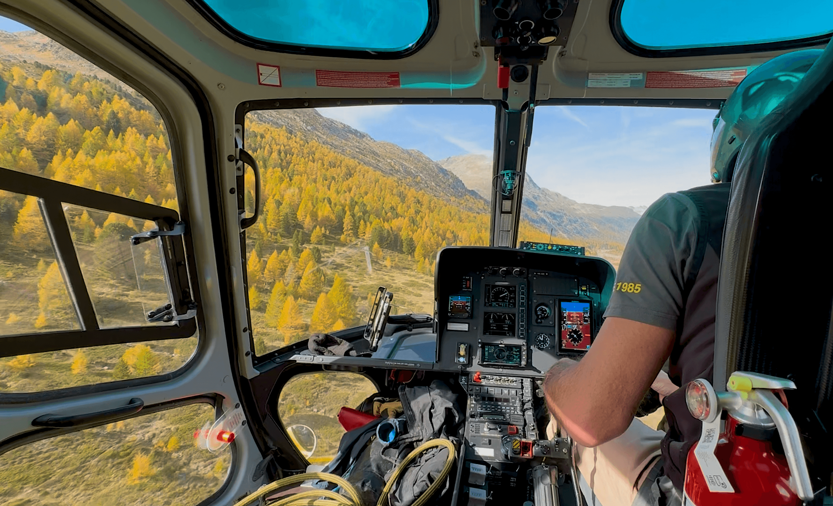 Herbst im Anflug: an Bord von Heli Bernina – mit Blick auf Engadiner Gipfel und goldene Lärchen.