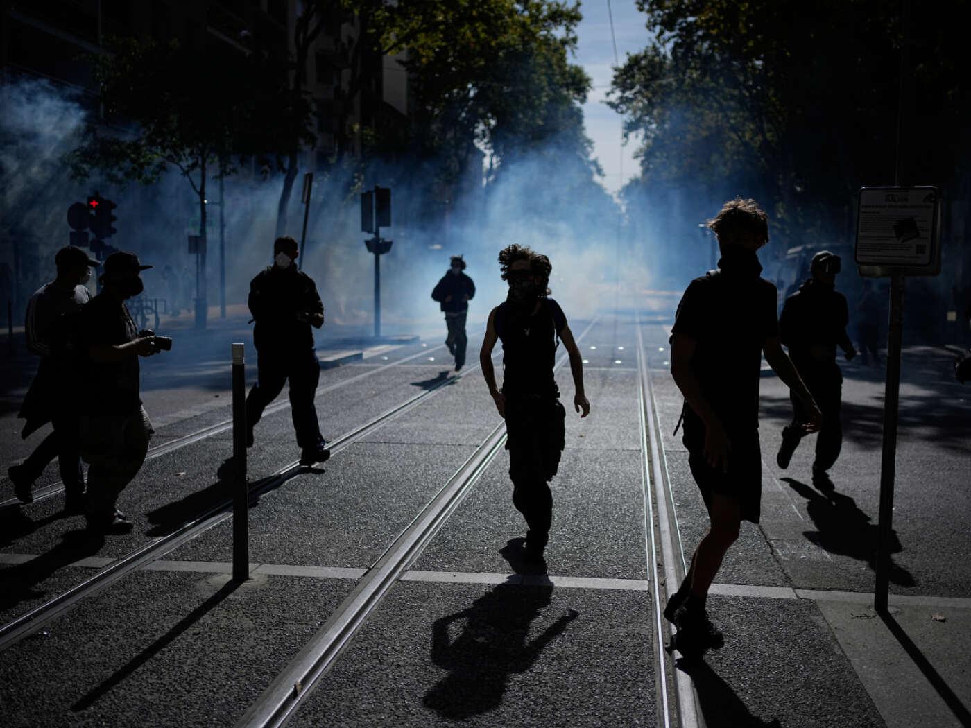 dpatopbilder - Bei einer Demonstration gegen unterfinanzierte Schulen rennen Schüler vor Tränengas weg. Seit Tagen protestieren Schülerinnen und Schüler an den Oberschulen. Foto: Laurent Cipriani/AP/dpa