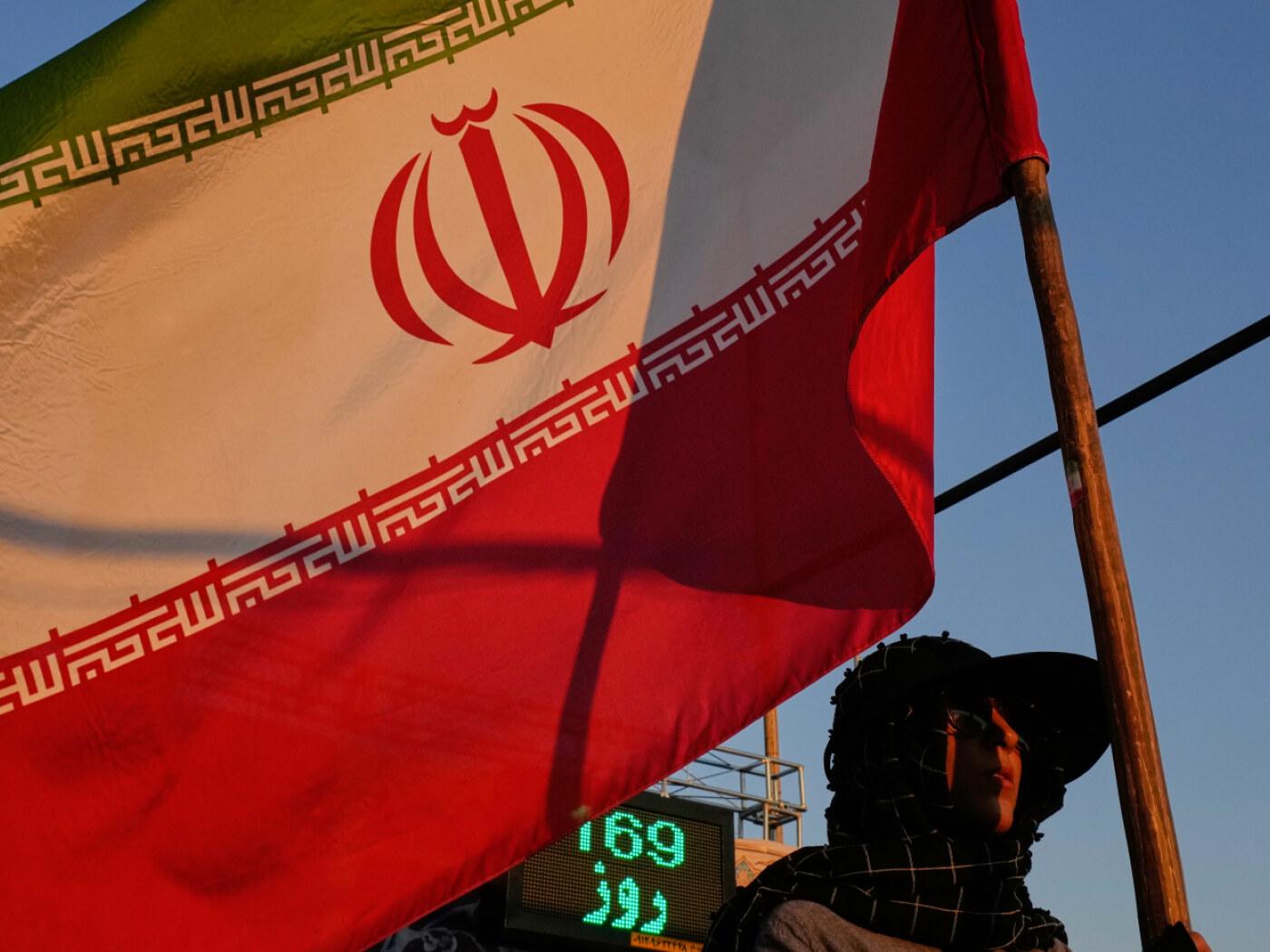 ARCHIV - Eine Frau mit einer iranischen Flagge in Teheran. Foto: Vahid Salemi/AP/dpa/Archivbild