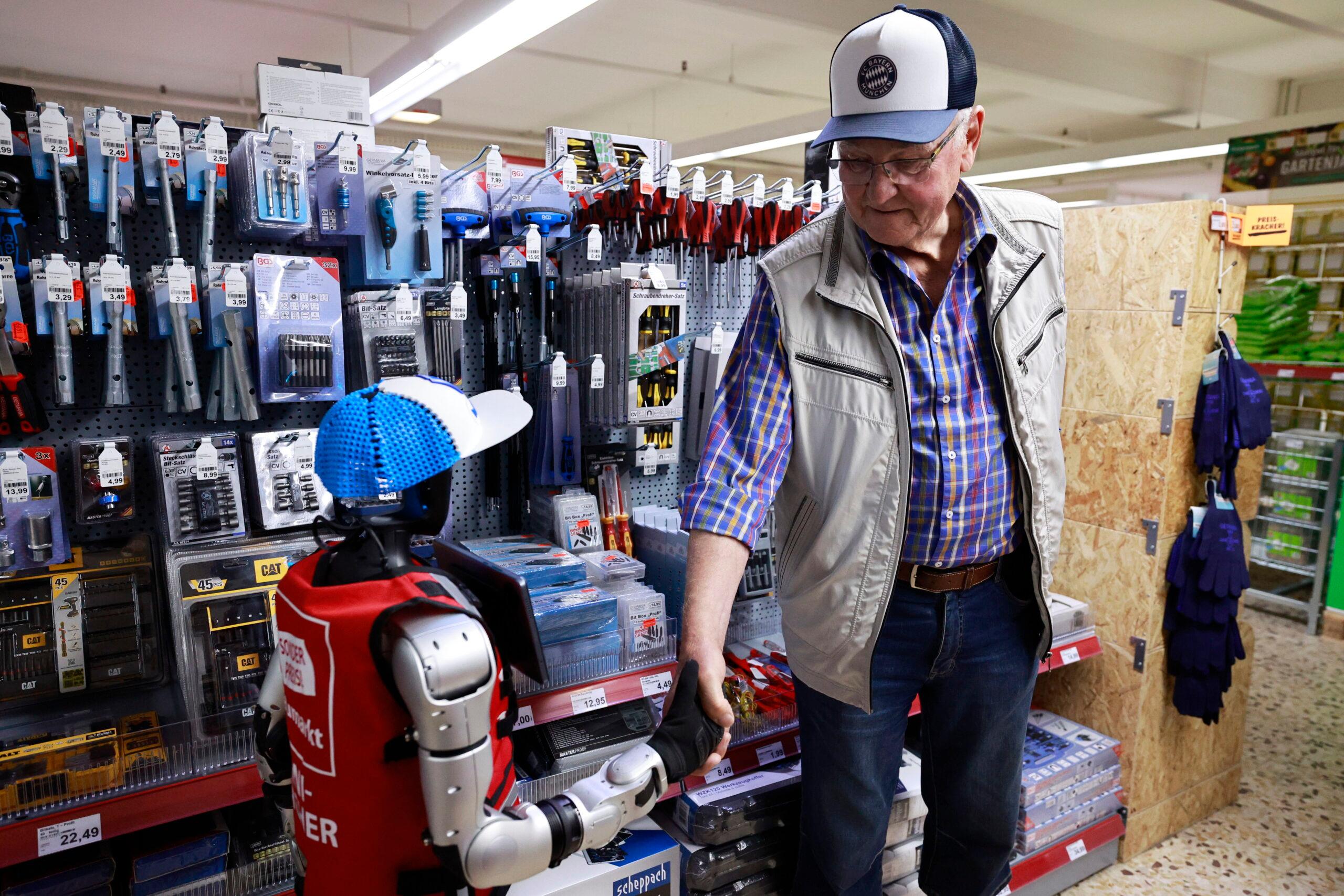 Soll Mitarbeitende unterstützen, nicht ersetzen: Ein humanoider Roboter reicht einem Kunden in einem Baumarkt in Süddeutschland die Hand.