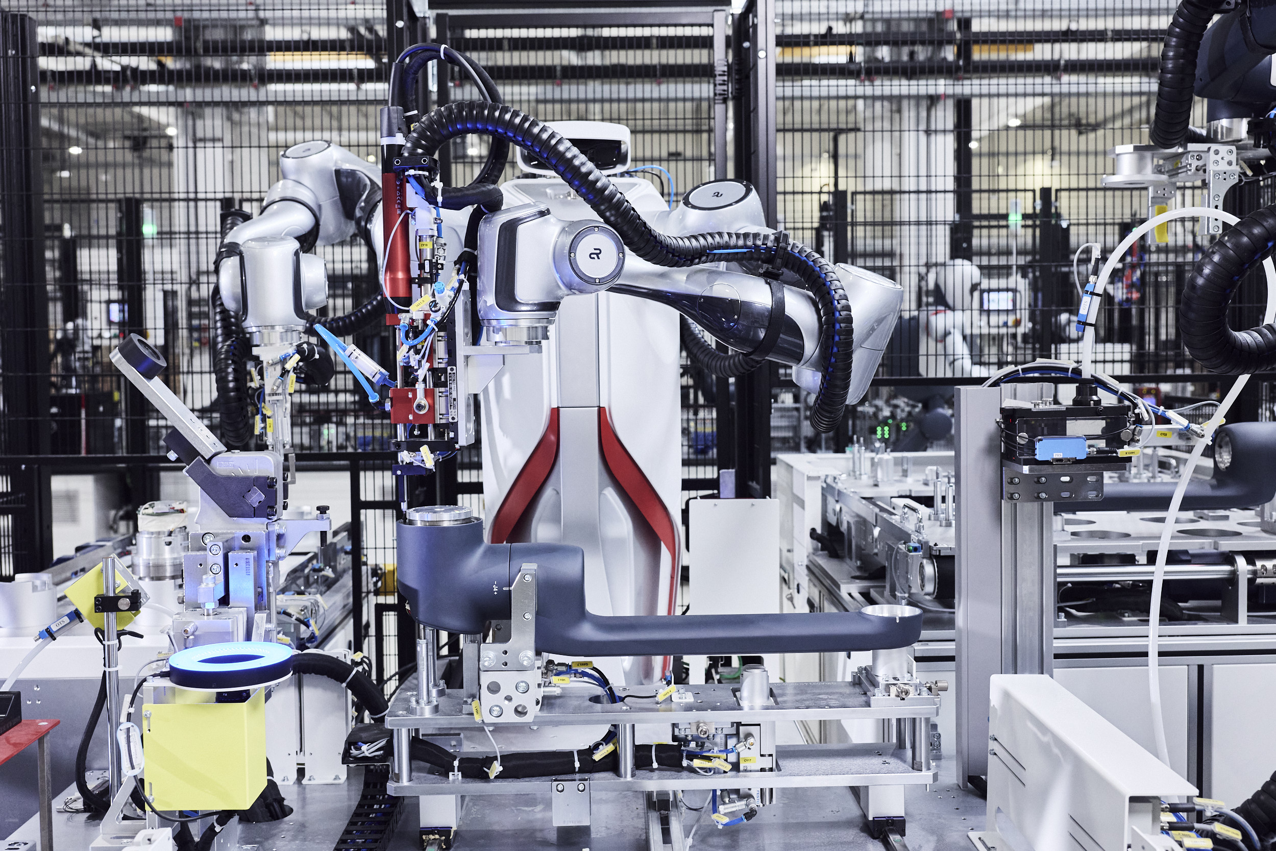 Ein zweiarmiger Roboter montiert einen Roboterarm