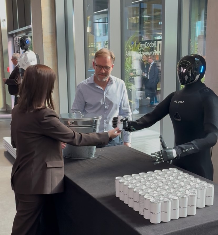 Alexandra Ilina bekommt vom Roboter eine Dose mit Secco.