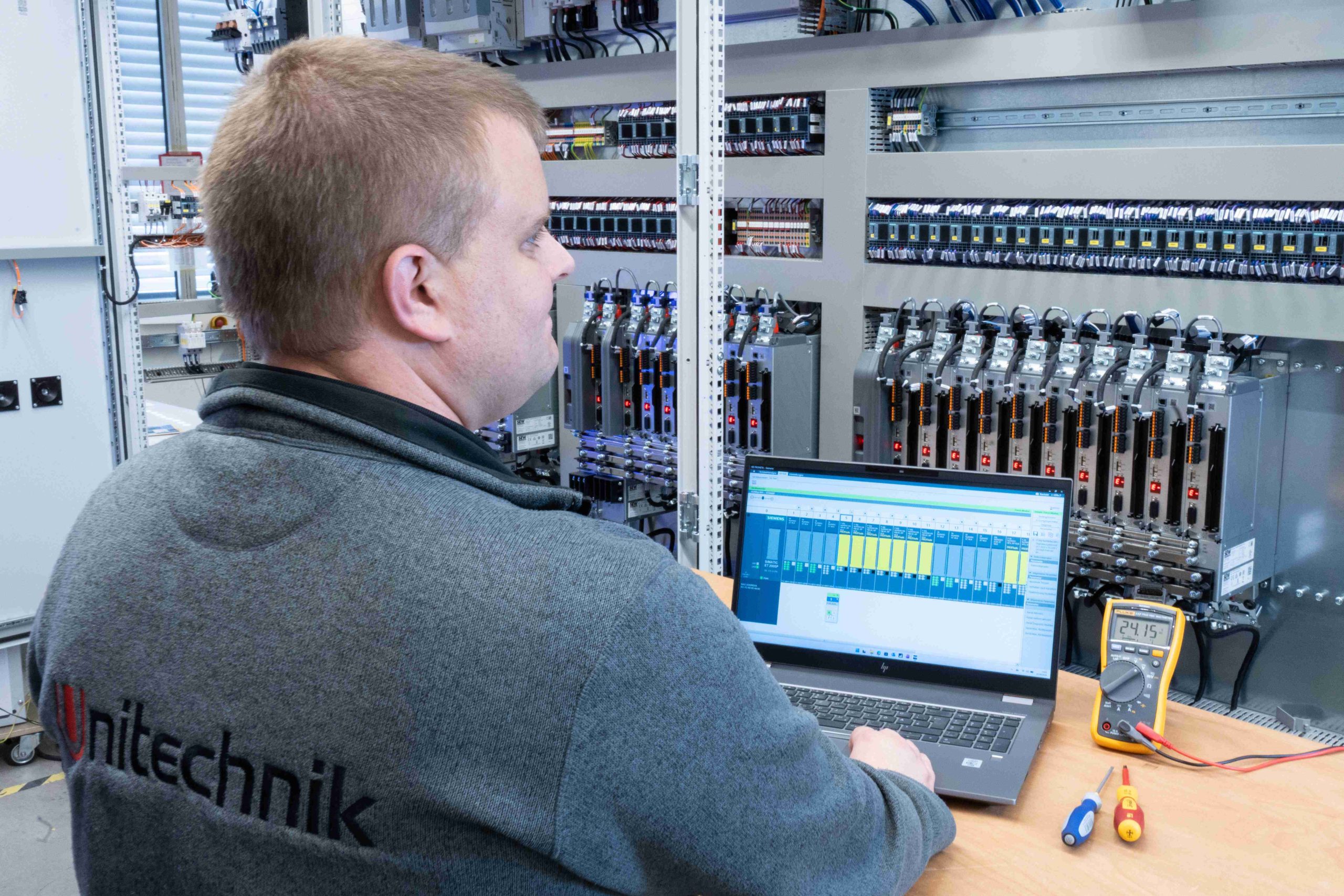 Mann prüft Funktion eines Schaltschrankes